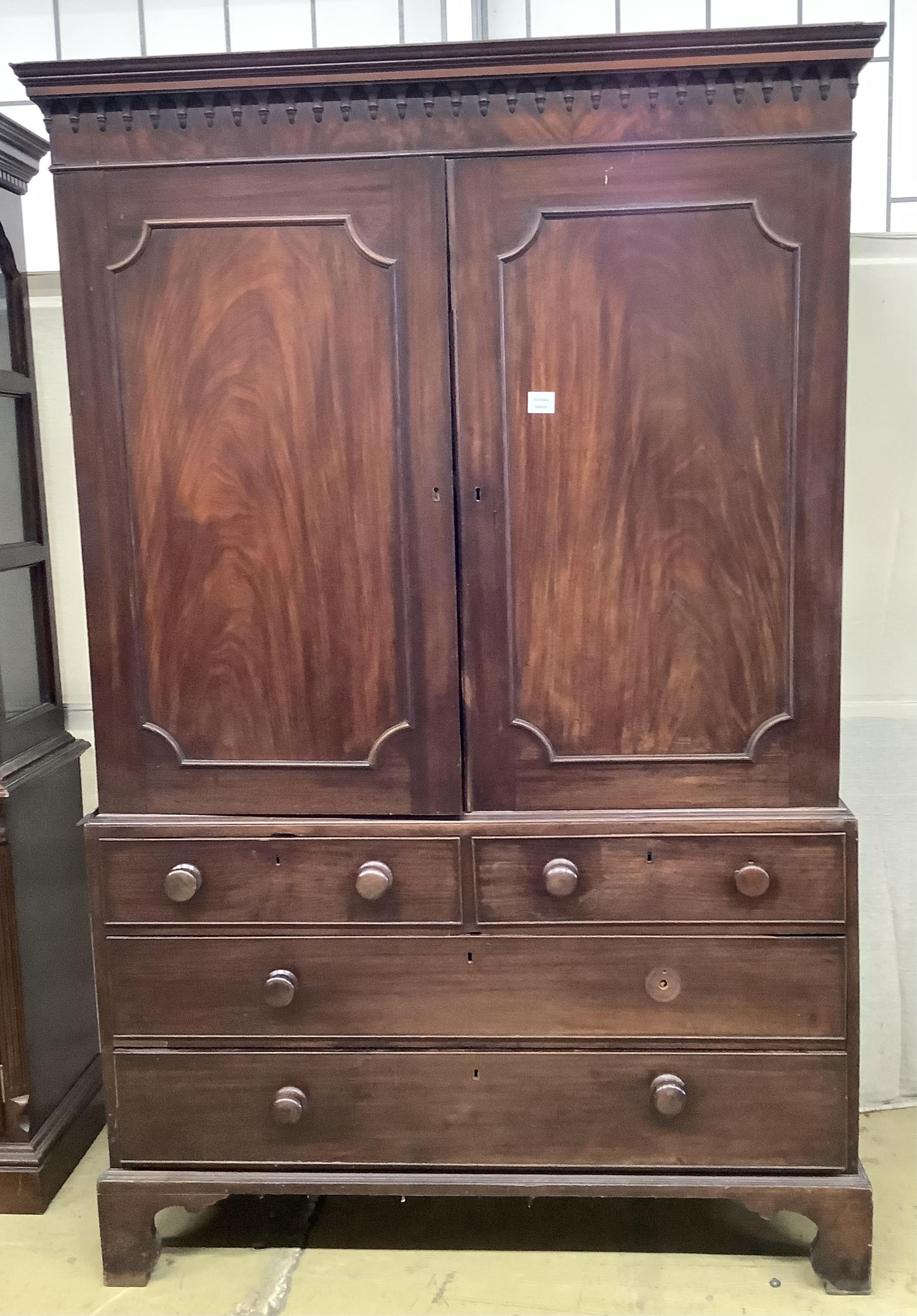 A George III mahogany linen press, the top retaining the original sliding trays, width 129cm, depth 56cm, height 201cm. Condition - poor